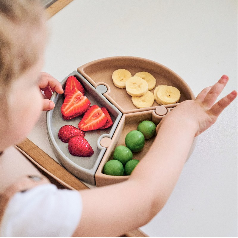 Assiette puzzle Minikoioi en silicone pour bébés dès 6 mois et toute l’enfance. Sa base à ventouse la gardera bien accrochée à la table. Disponible au Maroc chez MESAYOU. De marque MINIKOIOI qui est une marque d'accessoires pour bébé en silicone sans BPA et de très bonne qualité diversification alimentaire