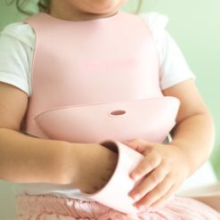 Bavoir avec système d'attache au dos de marque Minikoioi en silicone pour bébés dès 6 mois et toute l’enfance. Souple et facilement transportable, il accompagnera votre bébé durant ses premiers repas et préservera ses habits.